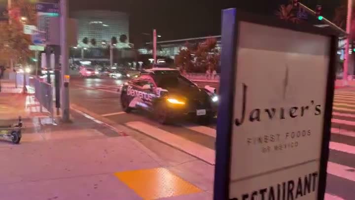 夜のダウンタウンLAの交差点を走る自動運転車